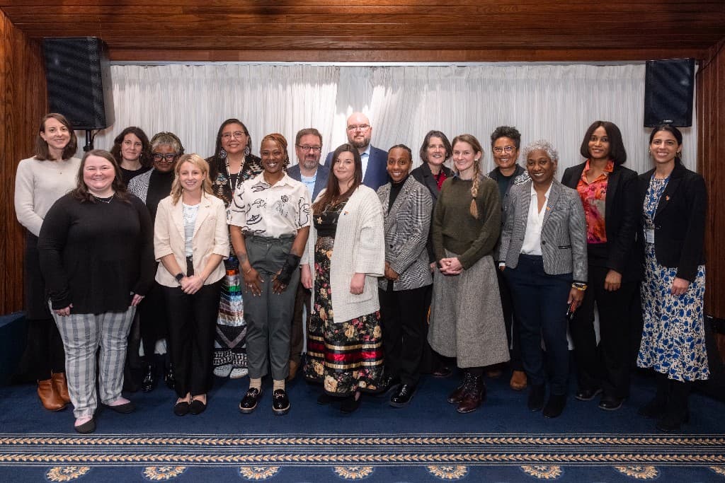 Diverse coalition members and partners posing together at an event